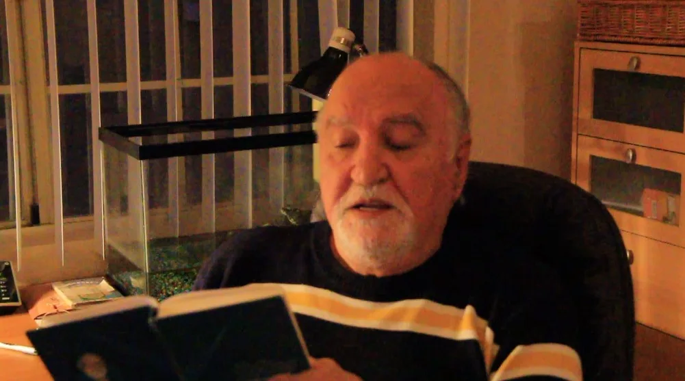 Ushangi Rizhinashvili reading his poems from a book